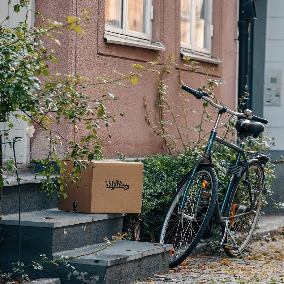 Låda från Mylla levererad vid en trappa bredvid en cykel